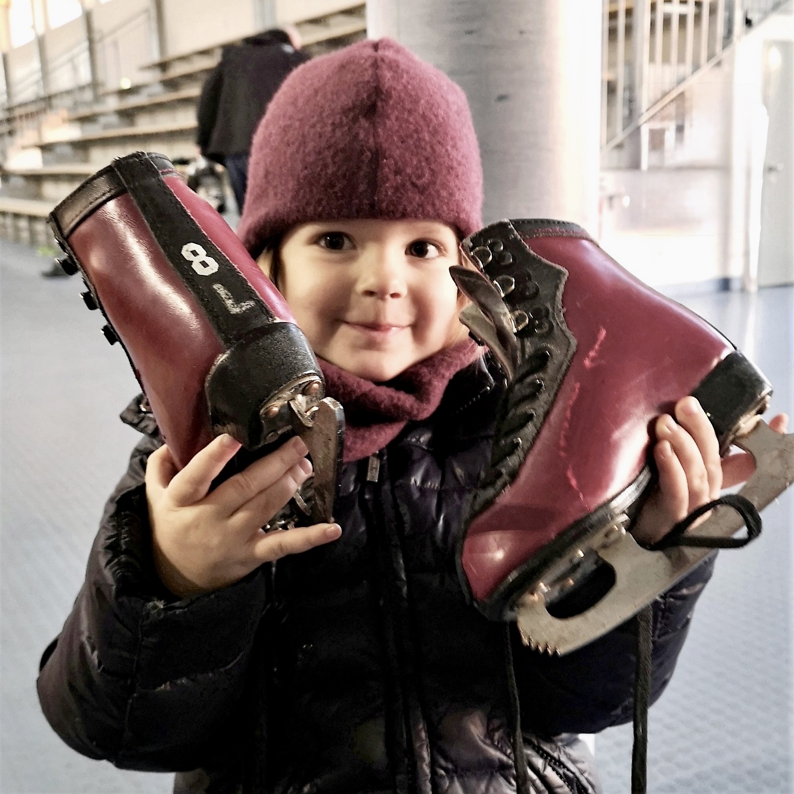 Mädchen hält Schlittschuhe hoch
